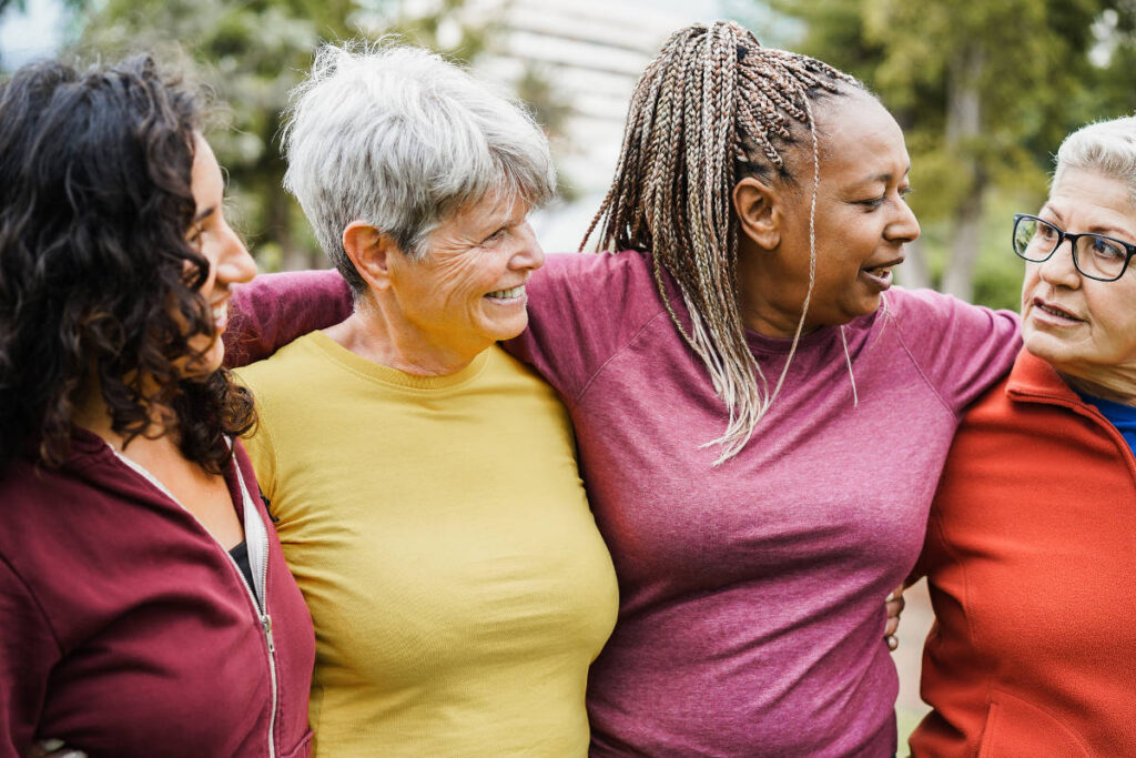 Group of multi generational women having fun together after sport workout outdoor - Focus on african female face